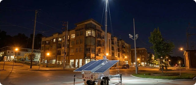 Trailer-mounted solar lighting system illuminating a residential area at night